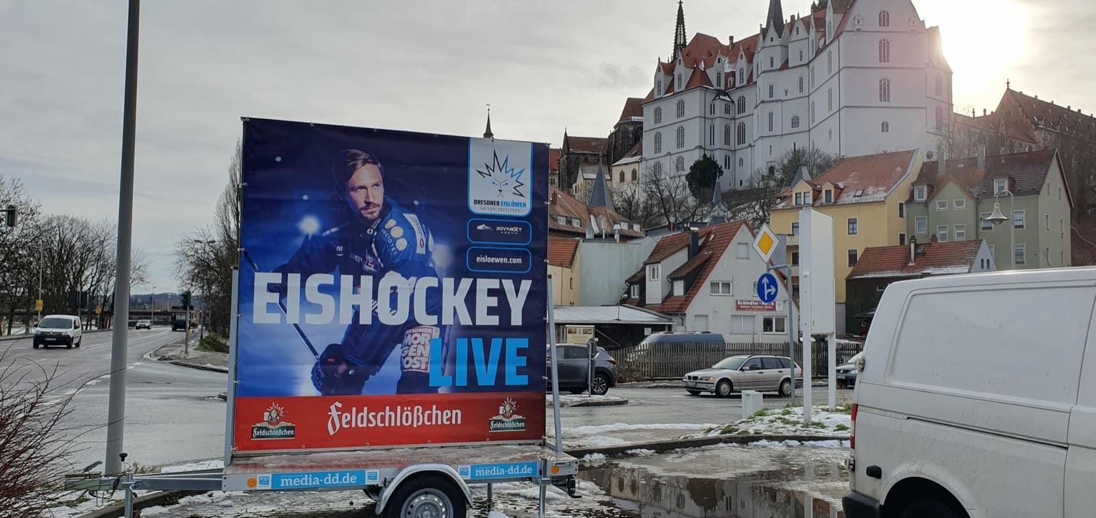 Werbeanhänger der Dresdner Eislöwen mit der Ankündigung „Eishockey live“, im Hintergrund die Albrechtsburg Meißen