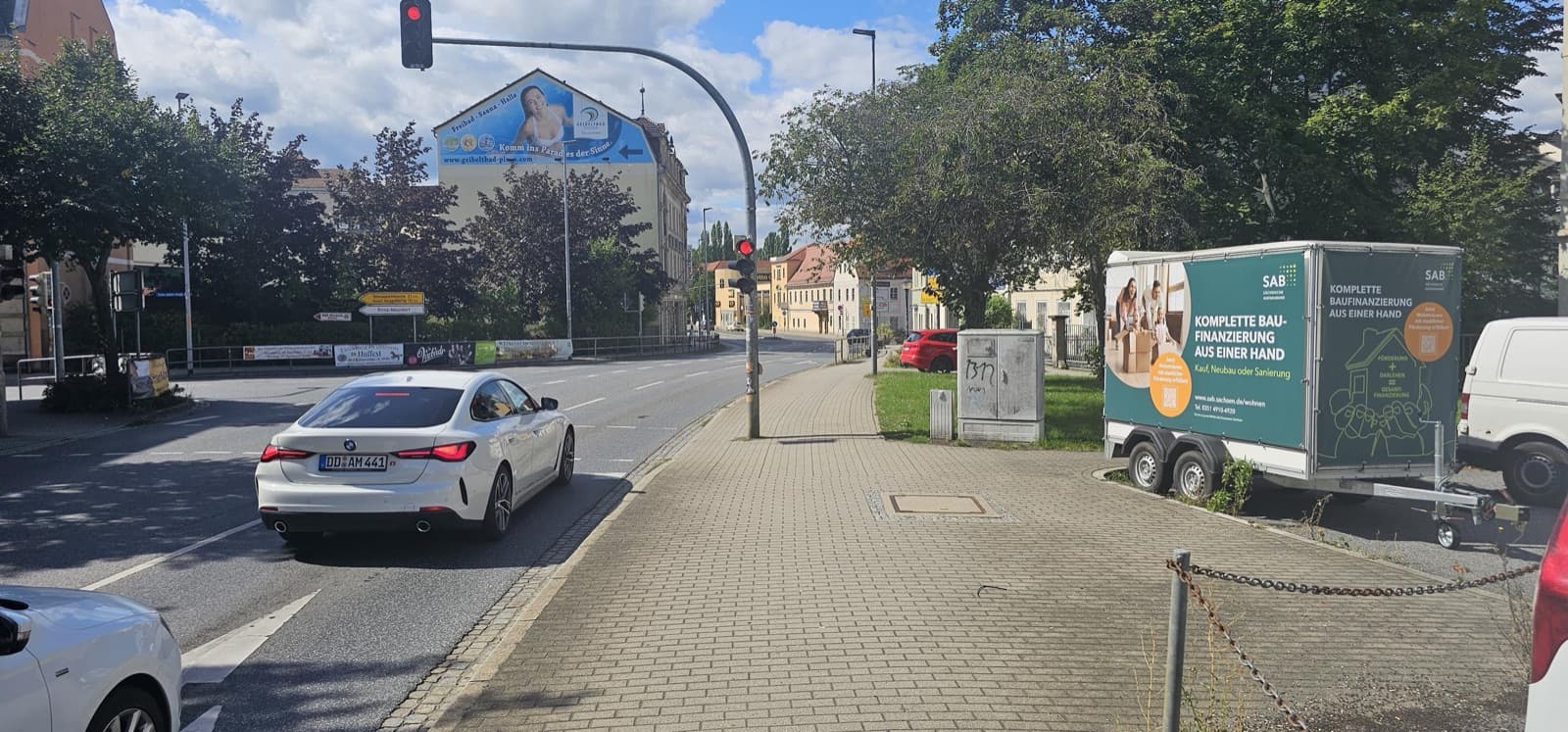 Vierseitiger Kofferanhänger mit Werbung, im Hintergrund eine Giebelwerbung